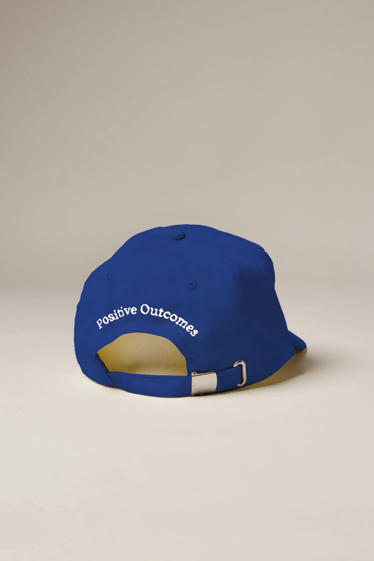 Blue cap with 'Positive Outcomes' text on a beige background