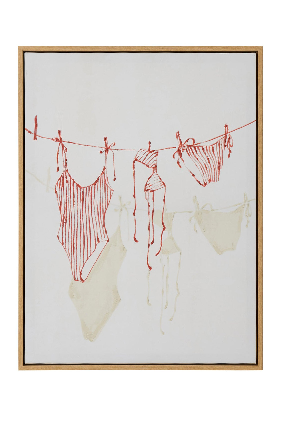 Framed artwork of swimsuits hanging on a line with a gold frame.