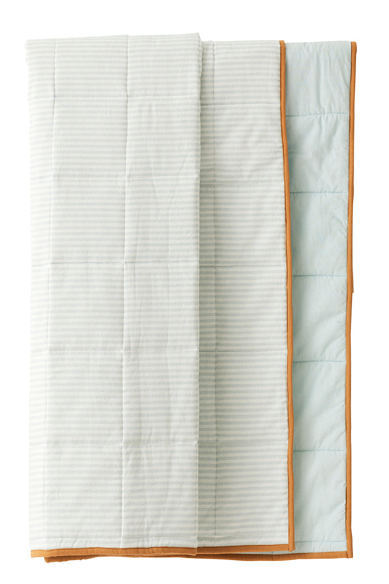 A folded quilted blanket with a white and light green striped pattern and a tan border, shown against a plain white background.