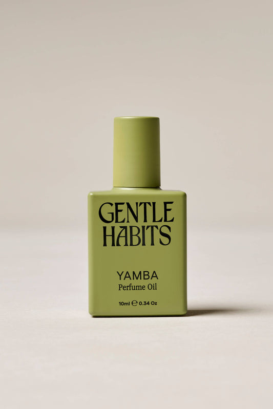 Green bottle of Gentle Habits Yamba perfume oil on a beige background