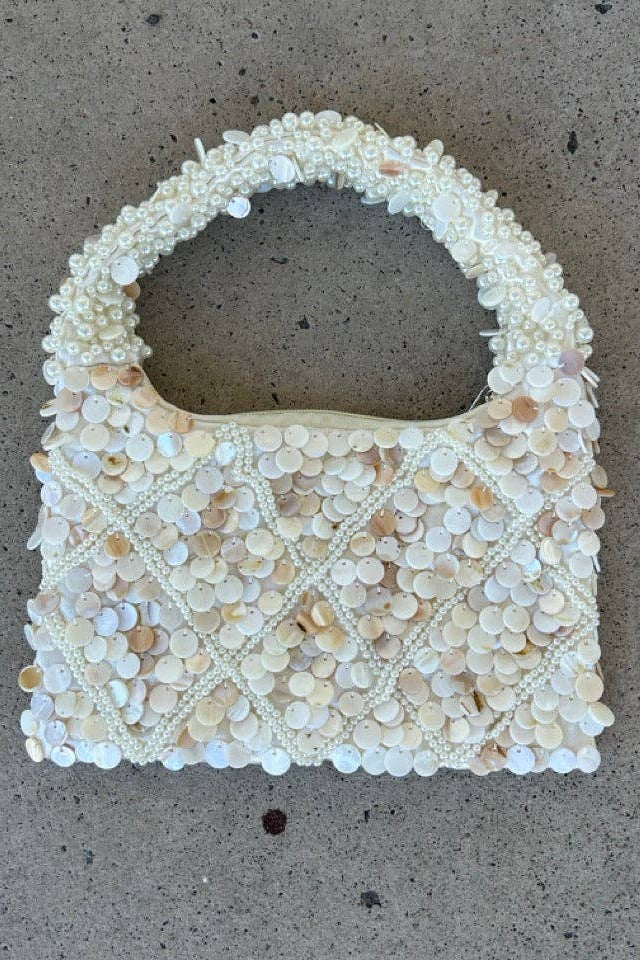Small handbag with bead embellishments on a concrete surface