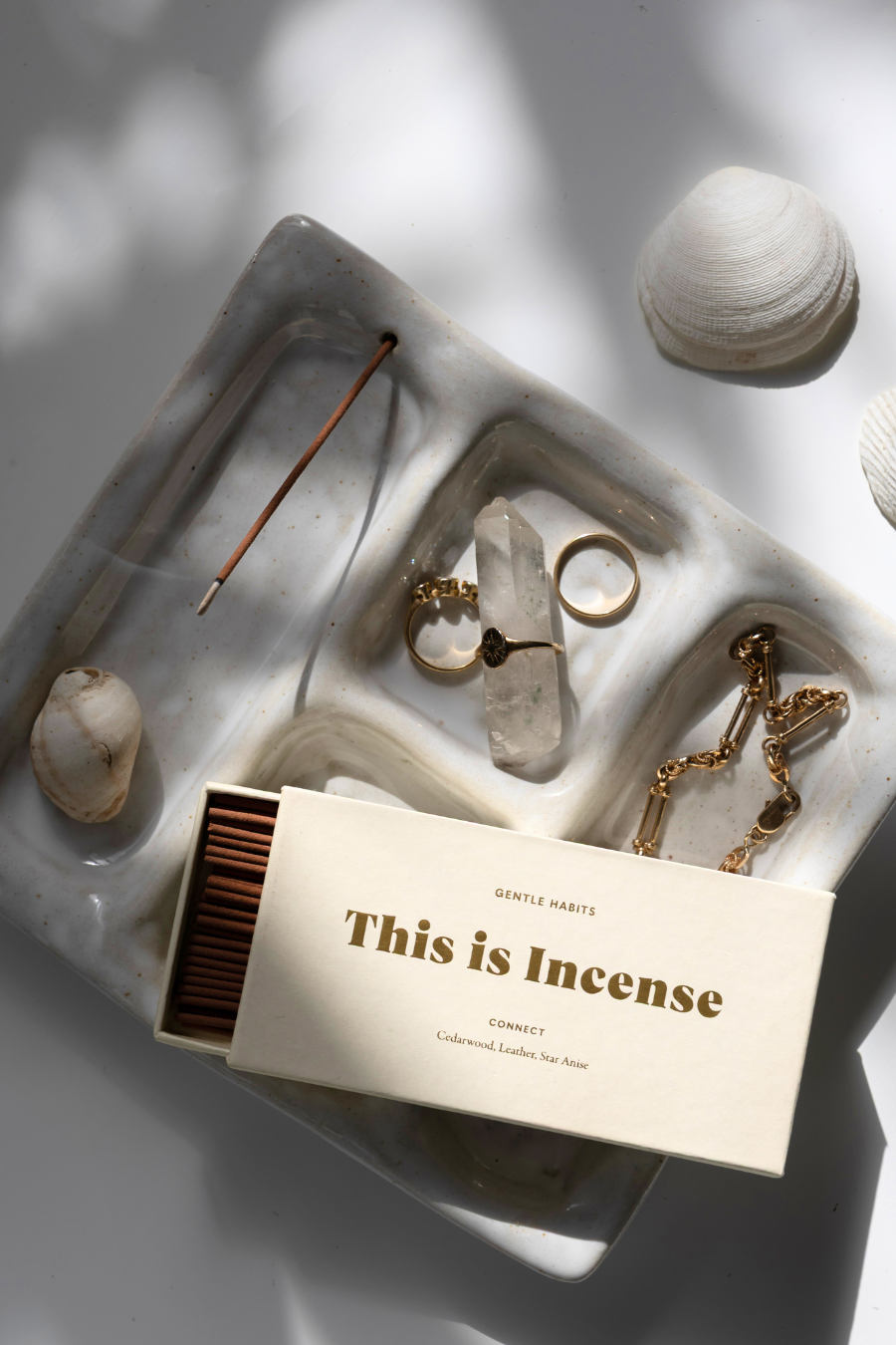 Incense sticks, matches, and decorative items on a textured surface with 'This is Incense' packaging.