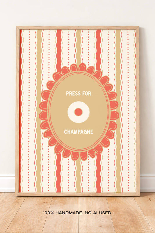 A framed vertical art print with a retro champagne press label design, leaning against a white wall on a light wood floor. The print features vertical stripes in warm coral, beige, and cream, surrounding a central circular badge with the text 'PRESS FOR CHAMPAGNE'.