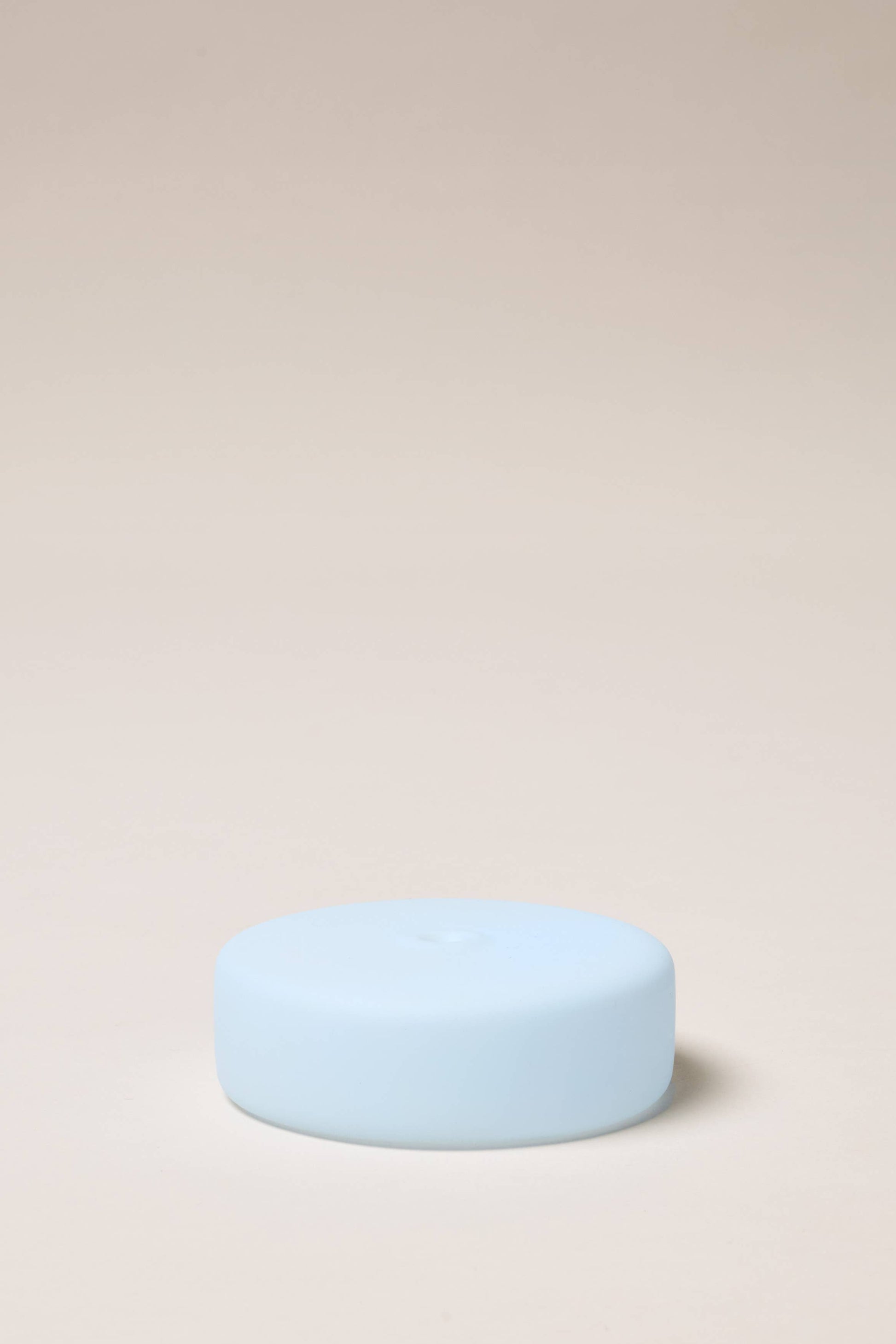Light blue cylindrical object on a beige background