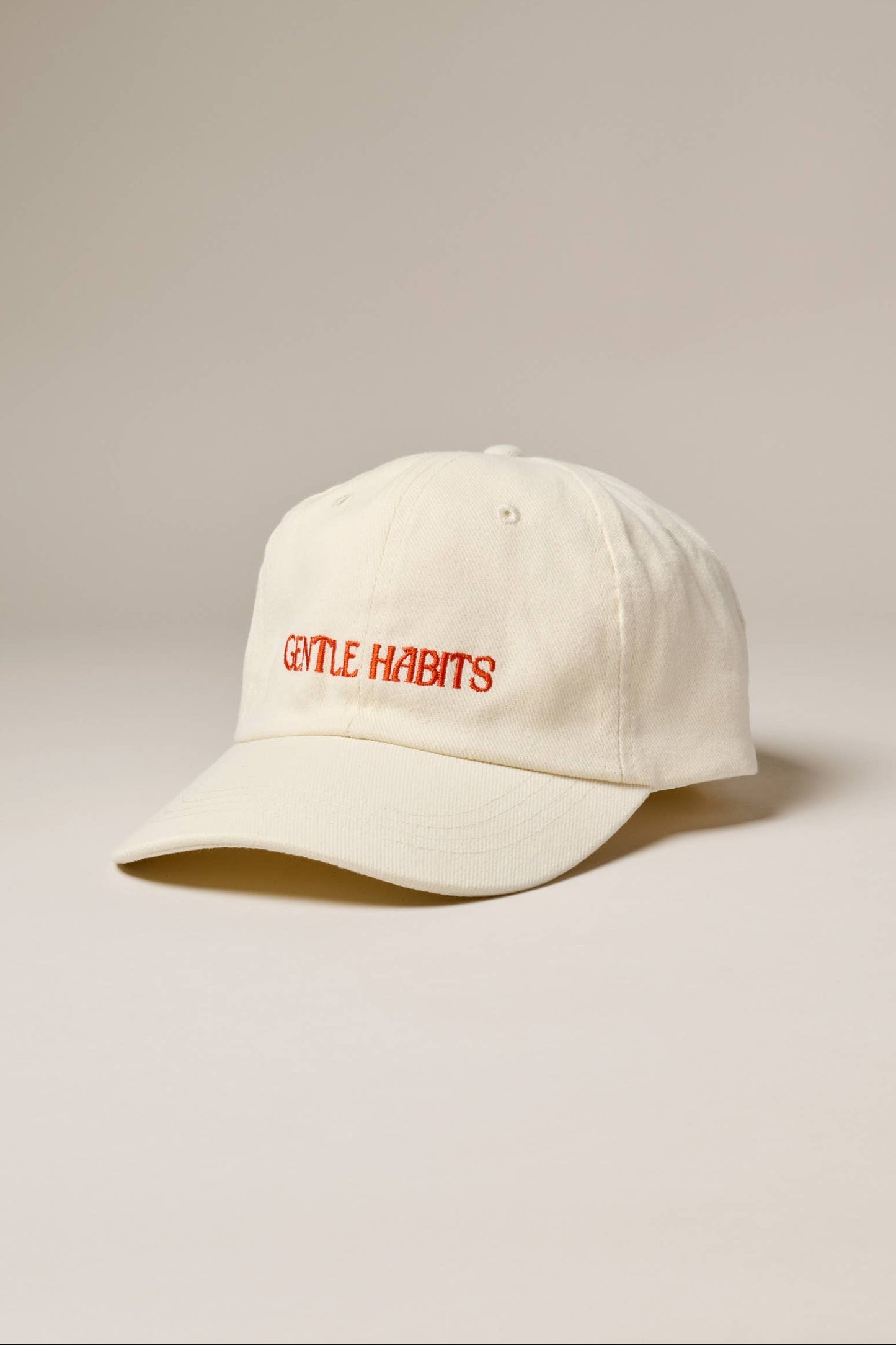 White cap with red text on a beige background