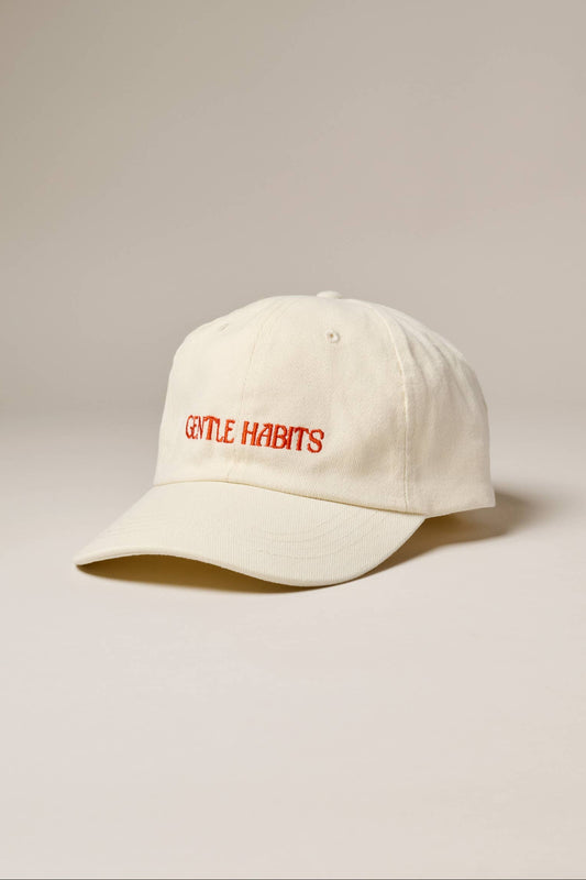 White cap with red text on a beige background