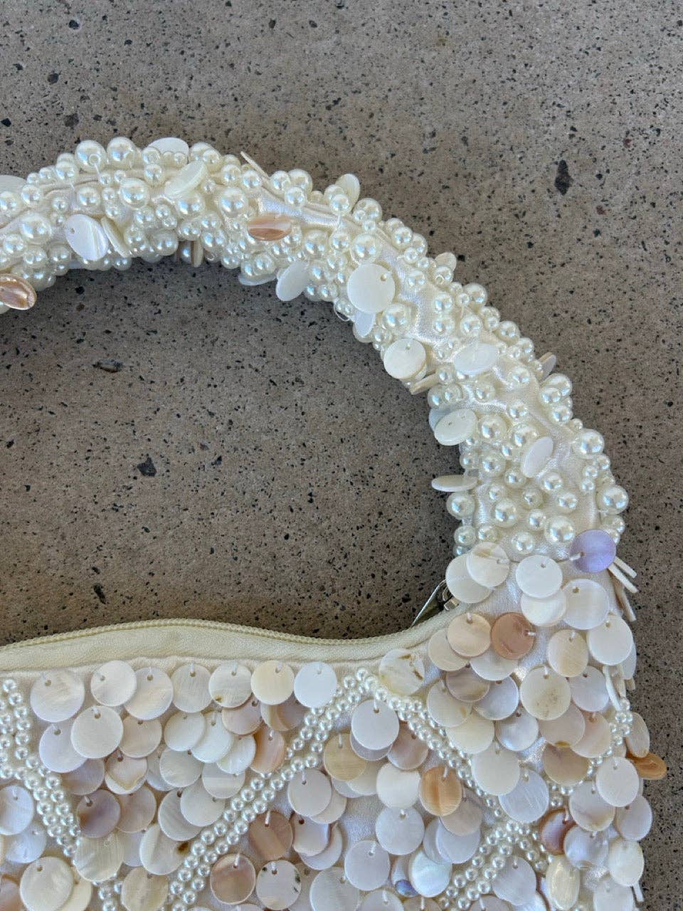 Pearl and shell handbag on a textured surface