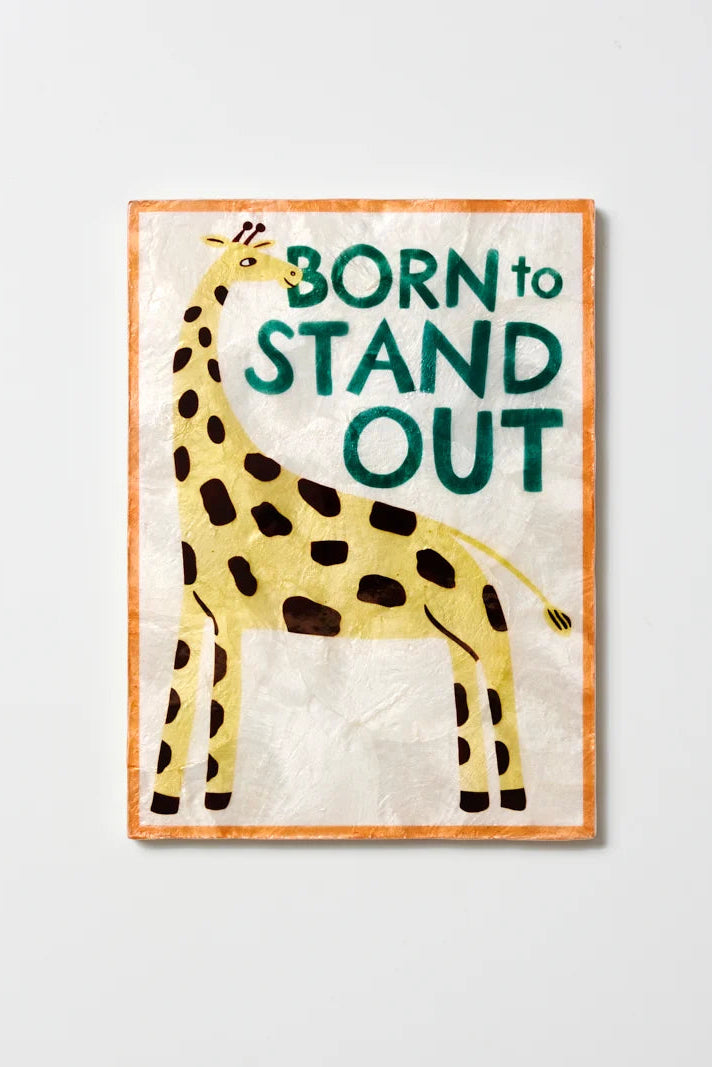 Framed artwork with a giraffe illustration and 'Born to Stand Out' text on a light gray background