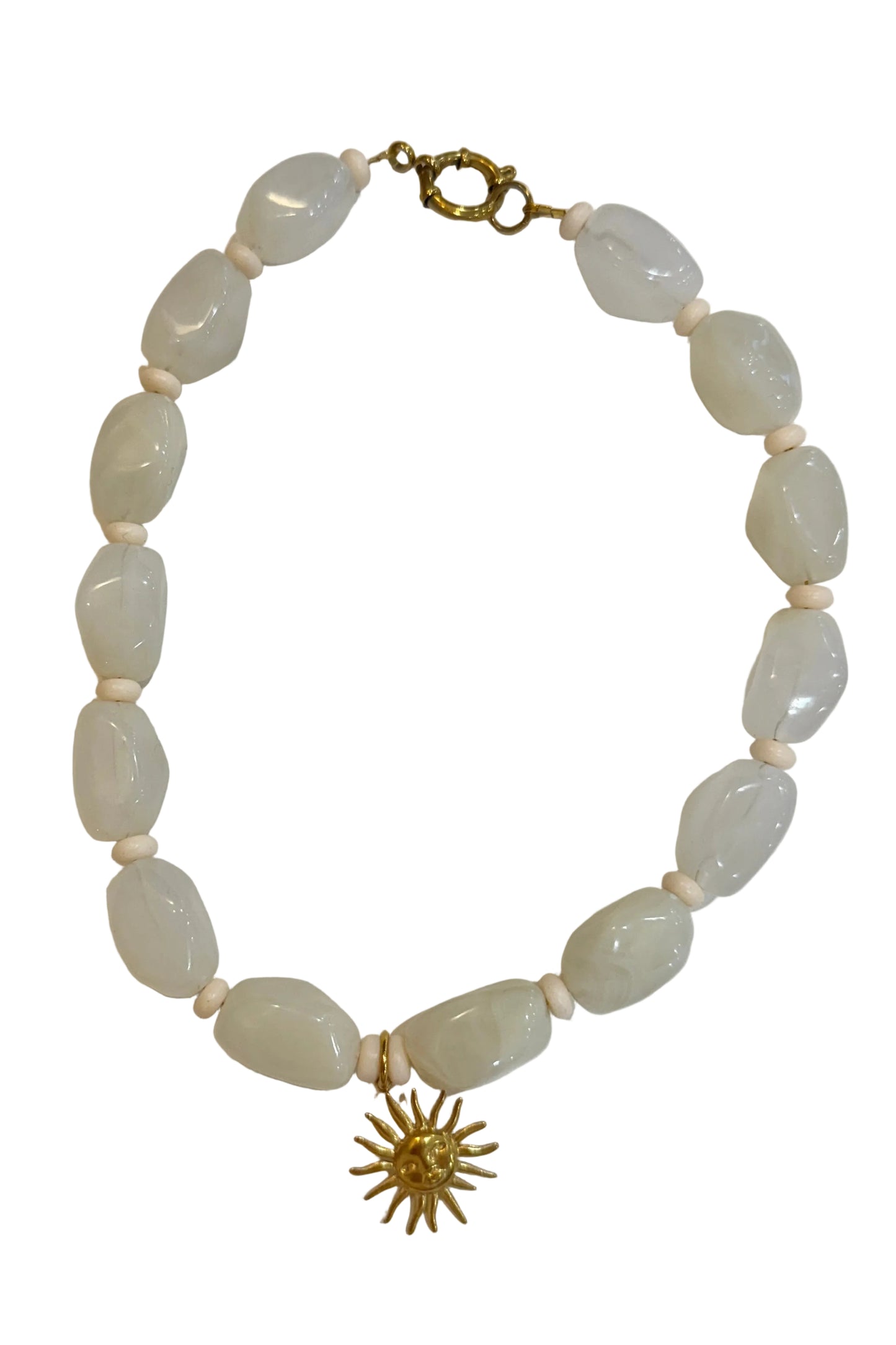 Necklace with light-colored beads and a gold sunflower charm on a white background