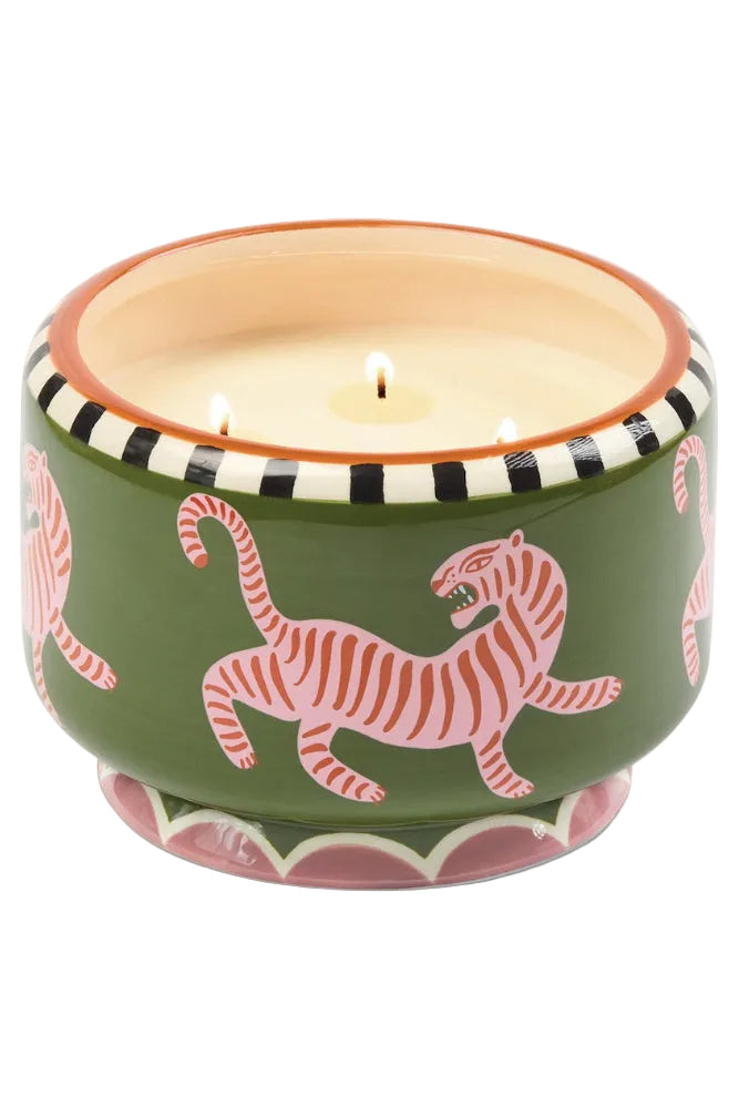 Candle in a decorative pot with pink tiger design on a white background