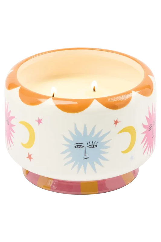 Decorative candle with sun and moon designs on a white background