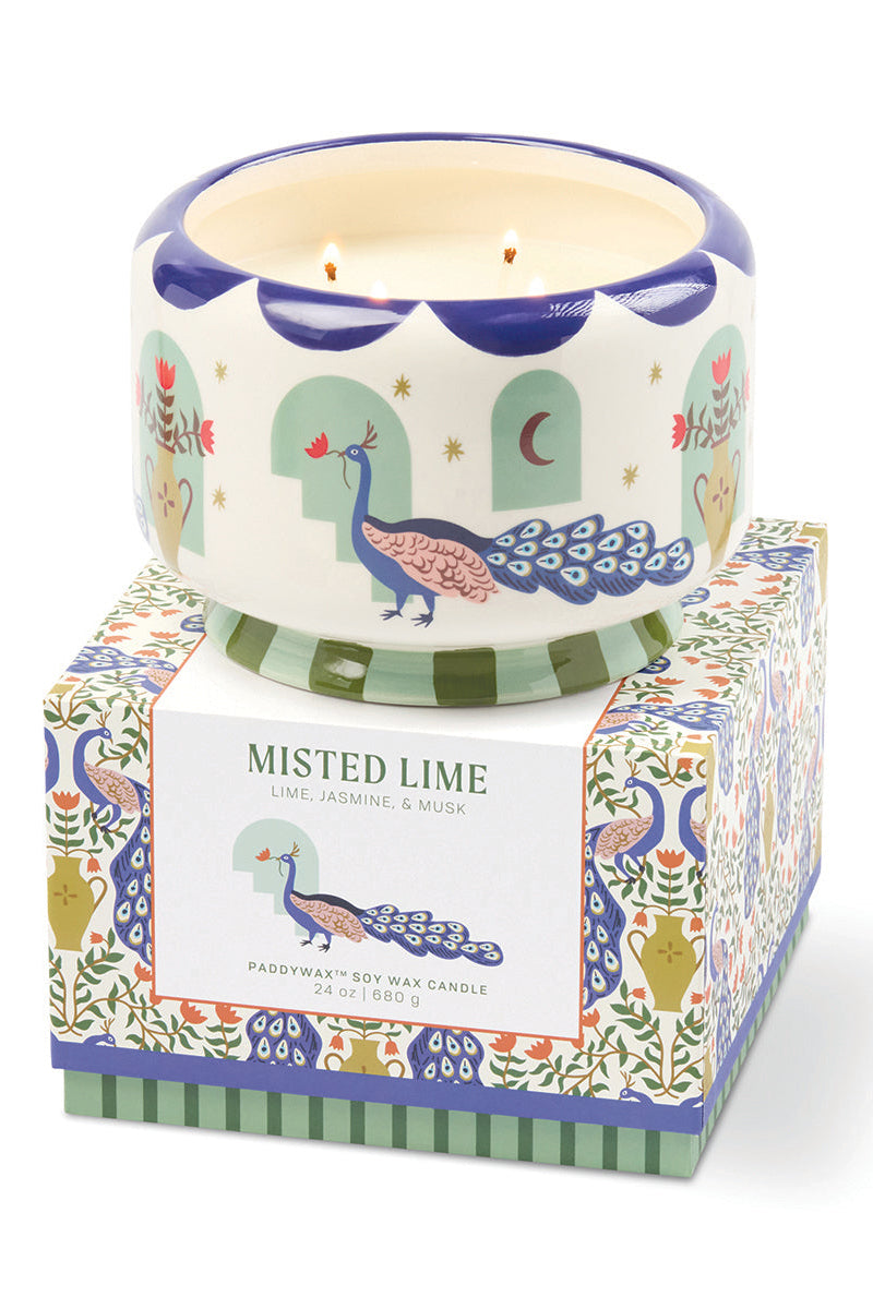 Decorative candle with peacock design on a matching box against a white background