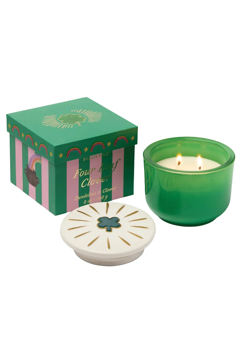 Green candle with decorative box and lid on a white background