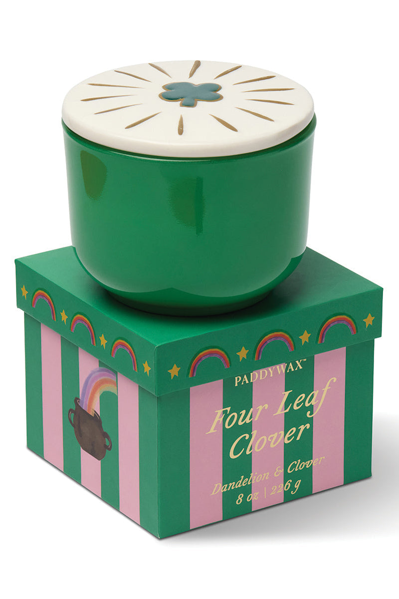 Green candle with white lid in a decorative box on a white background