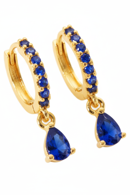 Gold hoop earrings with blue gemstones on a white background