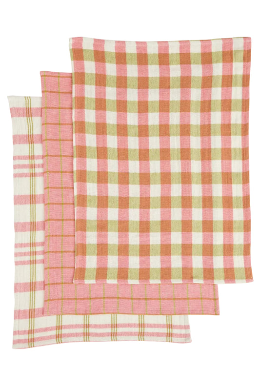 Three pink and green checkered towels on a white background