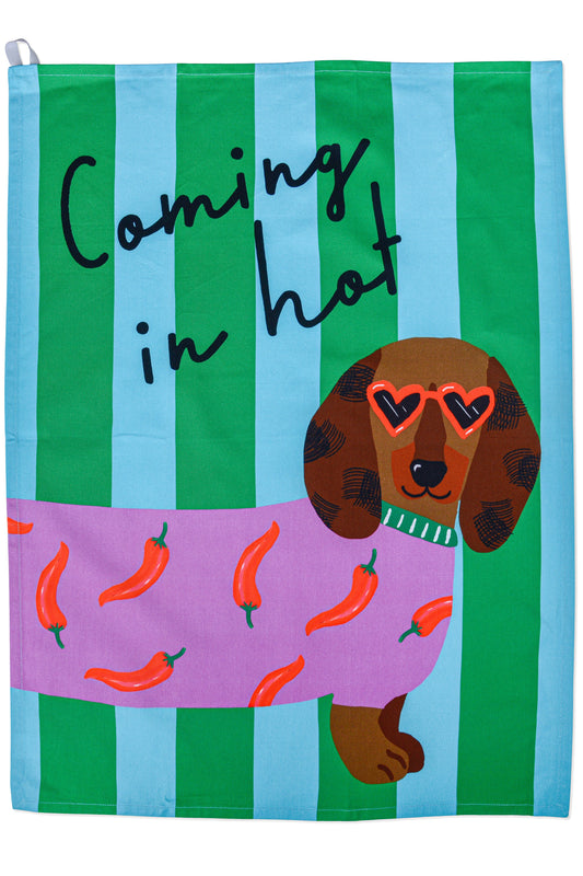 Tea towel with a dachshund wearing sunglasses and chili peppers, text 'Coming in hot', on a green and blue striped background.