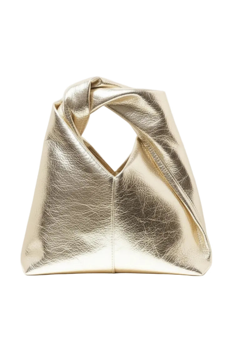A metallic gold clutch bag with a unique crisscross top handle, against a white background.