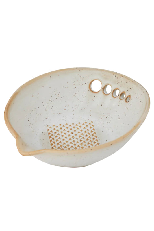 Speckled ceramic dish with textured design on a white background