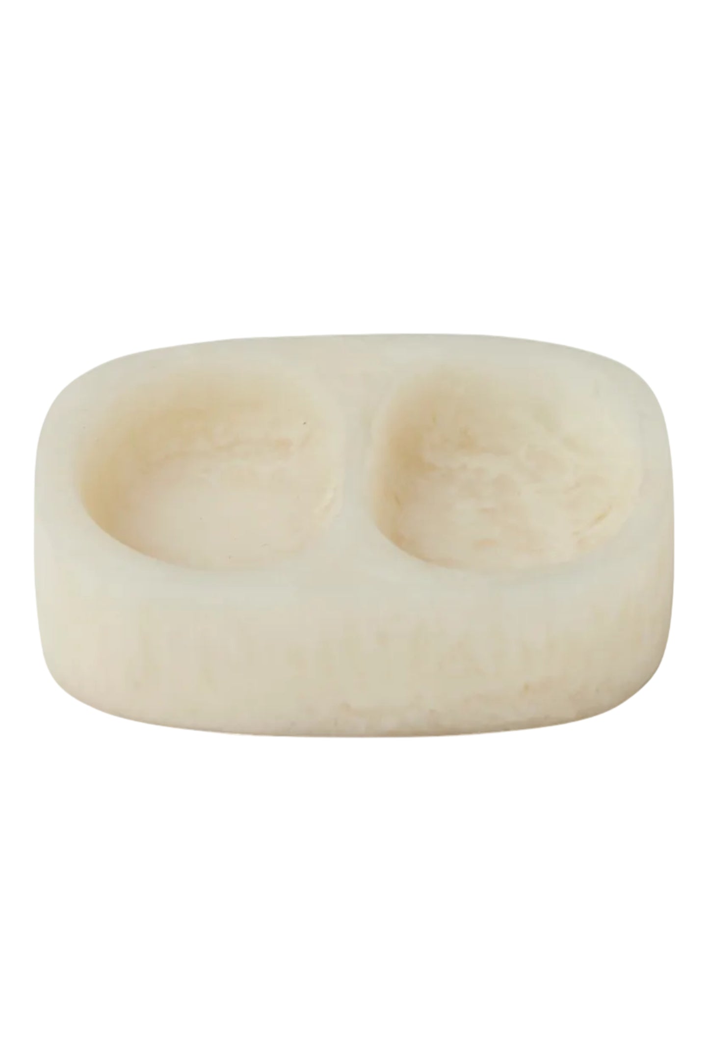 A double-compartment soap dish made of cream-colored stone, featuring a smooth, rounded rectangular shape with two oval indentations, shown on a solid white background.