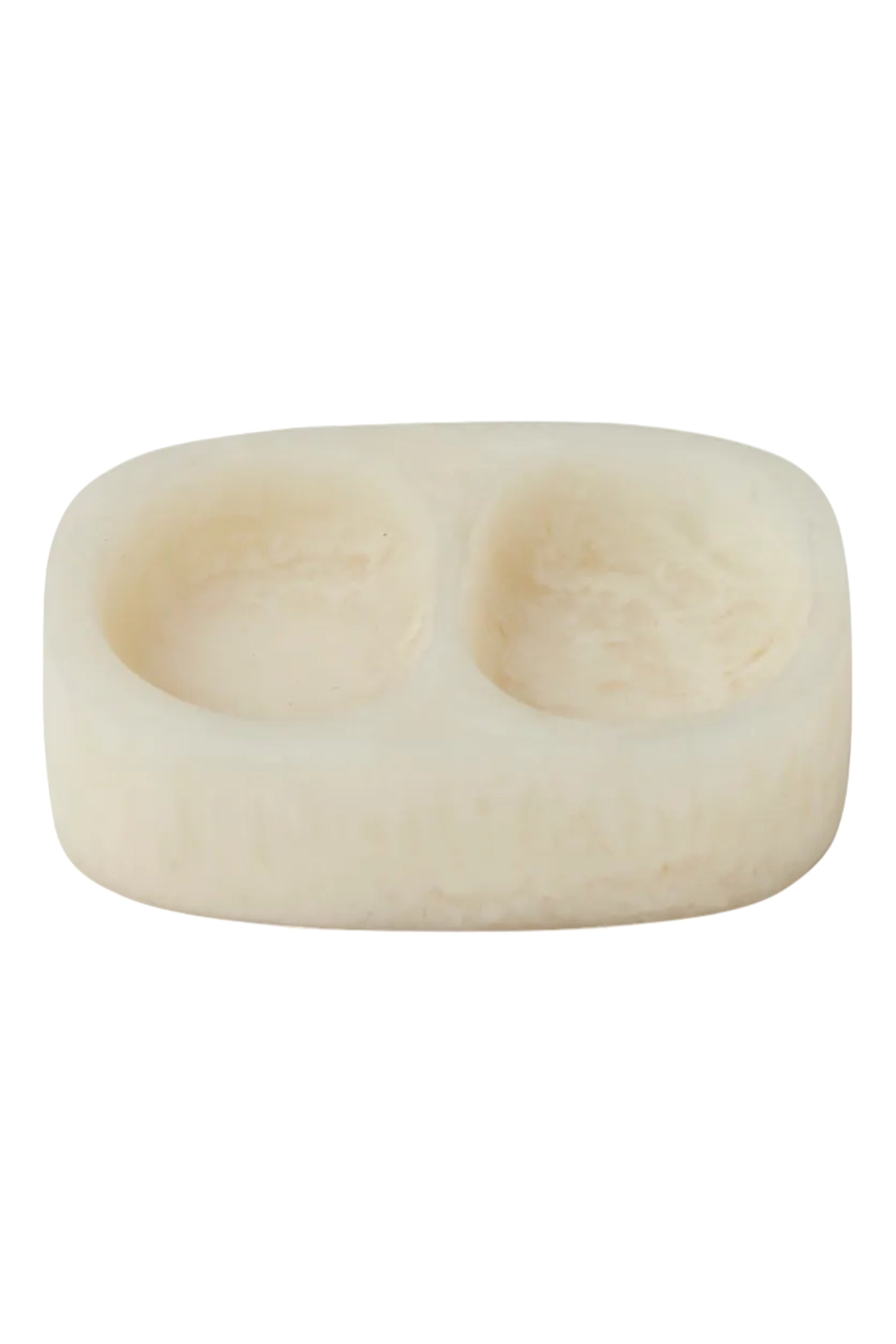 A double-compartment soap dish made of cream-colored stone, featuring a smooth, rounded rectangular shape with two oval indentations, shown on a solid white background.