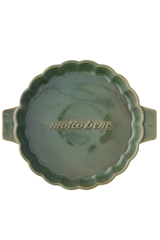 Green ceramic dish with scalloped edge and 'molto bene' text on a white background