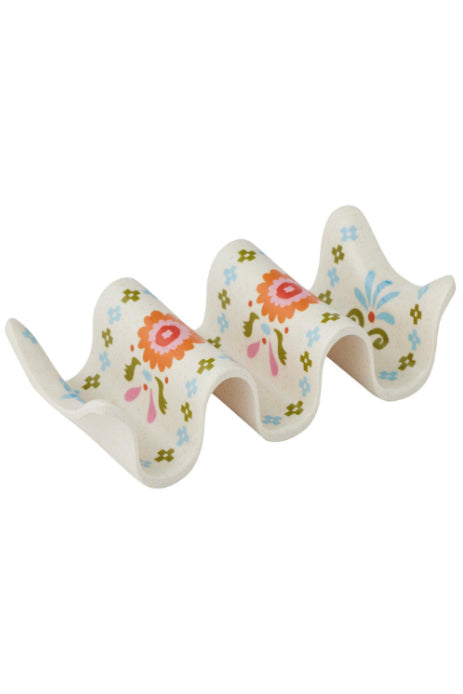 A wavy ceramic dish rack with a white base decorated with colorful floral and leaf patterns in orange, pink, blue, and green, shown on a plain white background.
