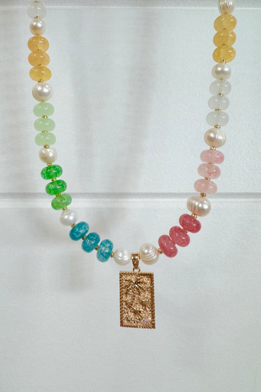 Necklace with multicolored beads and a rectangular pendant on a white background