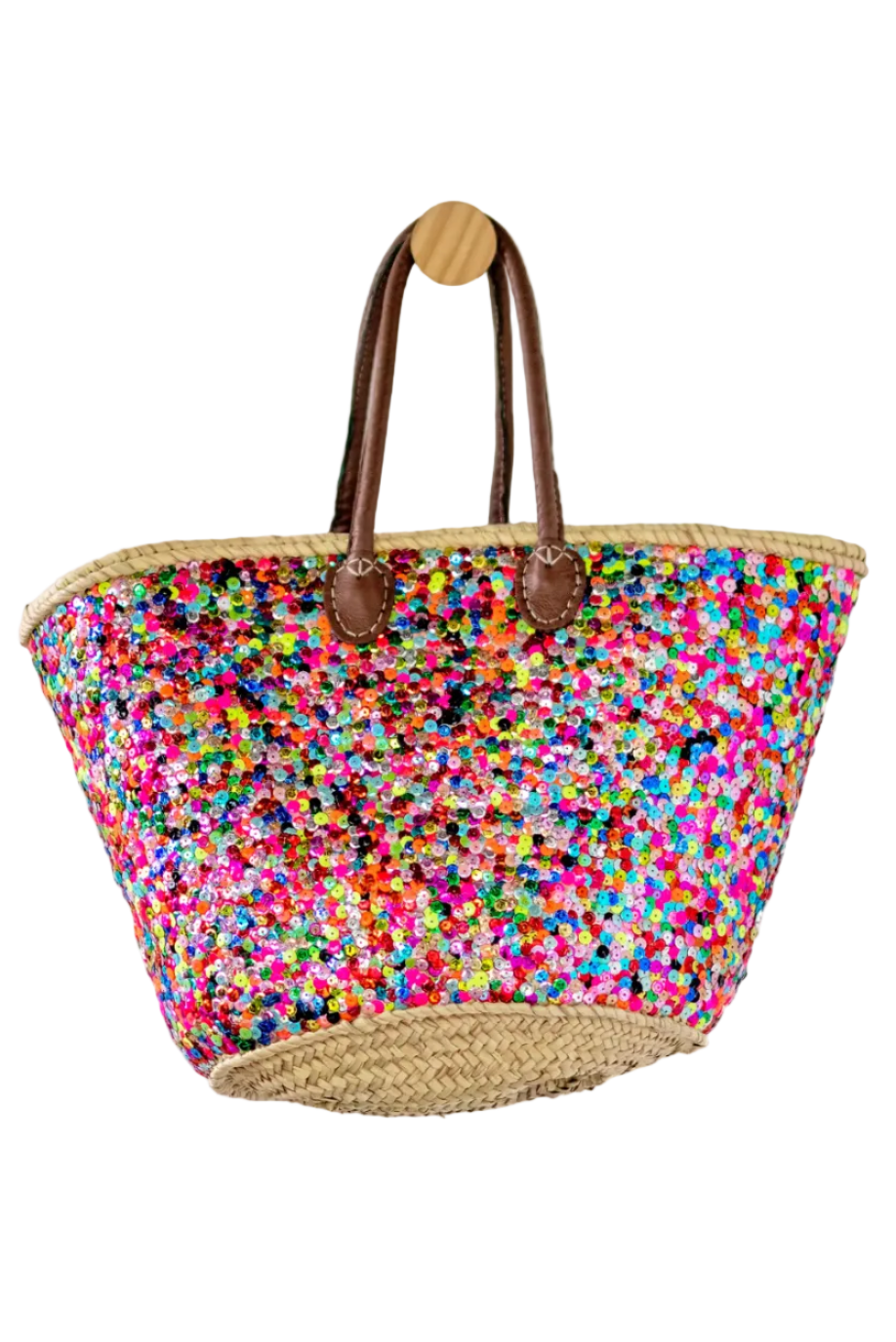 A large woven tote bag with a vibrant multicolor sequin pattern on the body, natural jute trim, brown leather handles, and a natural straw bottom, hanging from a wooden peg against a white background.