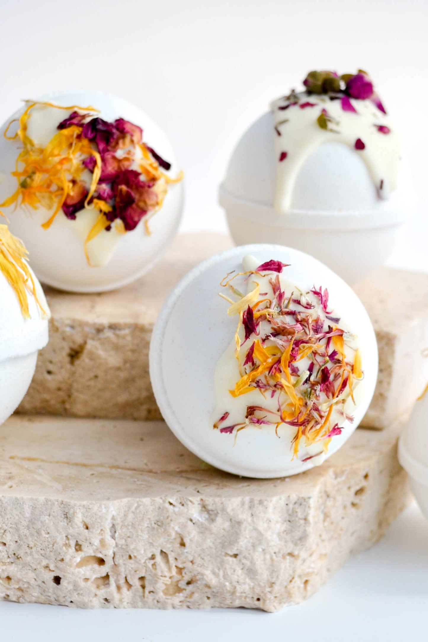 White bath bombs with decorative elements on a wooden block against a white background
