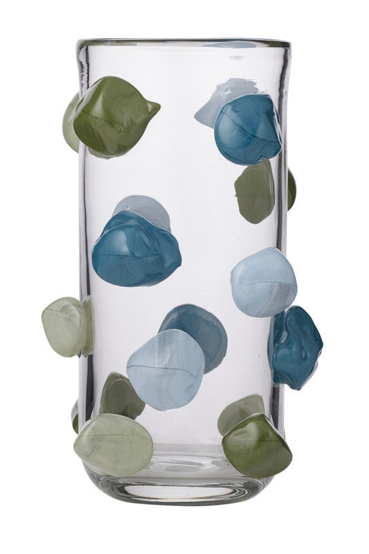 A clear cylindrical glass vase decorated with raised, organic-shaped pebble-like accents in shades of blue, green, and pale gray, shown on a plain white background.