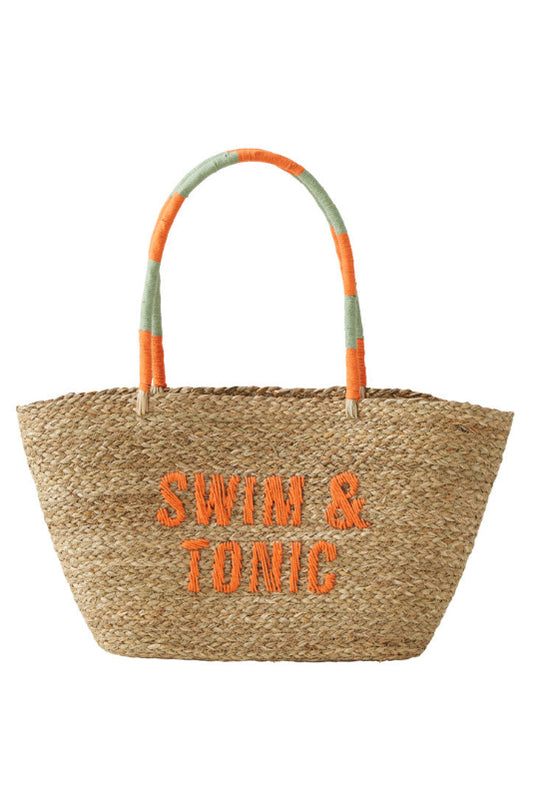 A woven straw beach tote bag with orange embroidered 'SWIM & TONIC' text on the front and striped orange and sage green handles, shown on a plain white background.