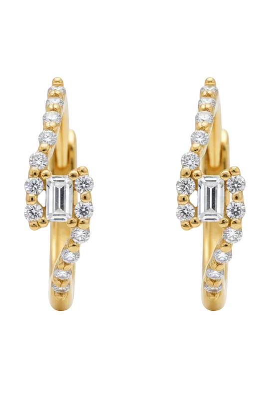 Gold heart-shaped earring with clear gemstones on a light background