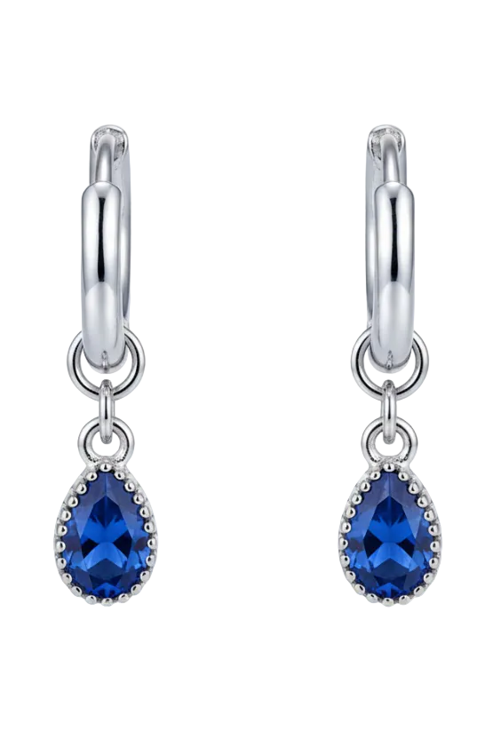 Silver earring with a blue gemstone on a beige background