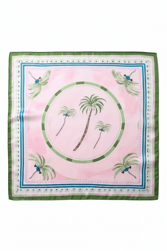 A square silk scarf with a light pink background, featuring a central green circular motif with palm trees, four matching palm trees in the corners, and two green-and-blue peacock motifs near the borders. The scarf is displayed flat against a light gray background.