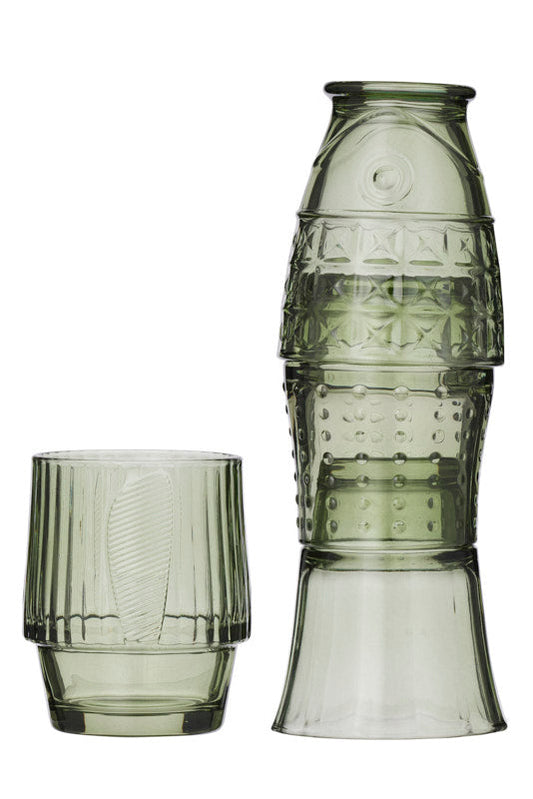 A set of translucent smoky green glassware, featuring 4 short unique shaped tumblers with vertical fluting, set against a plain white background.