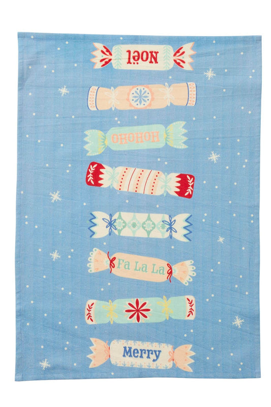 A rectangular blue tea towel with a festive Christmas design, featuring illustrated candy canes and snowflakes in pastel colors and white text, shown flat against a white background.