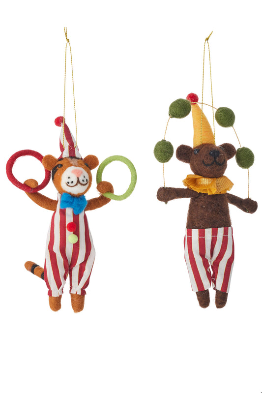 Two felt teddy bear Christmas ornaments hanging against a white background. One ornament is a tiger in a red and white striped outfit with a blue bow tie and ring juggling.