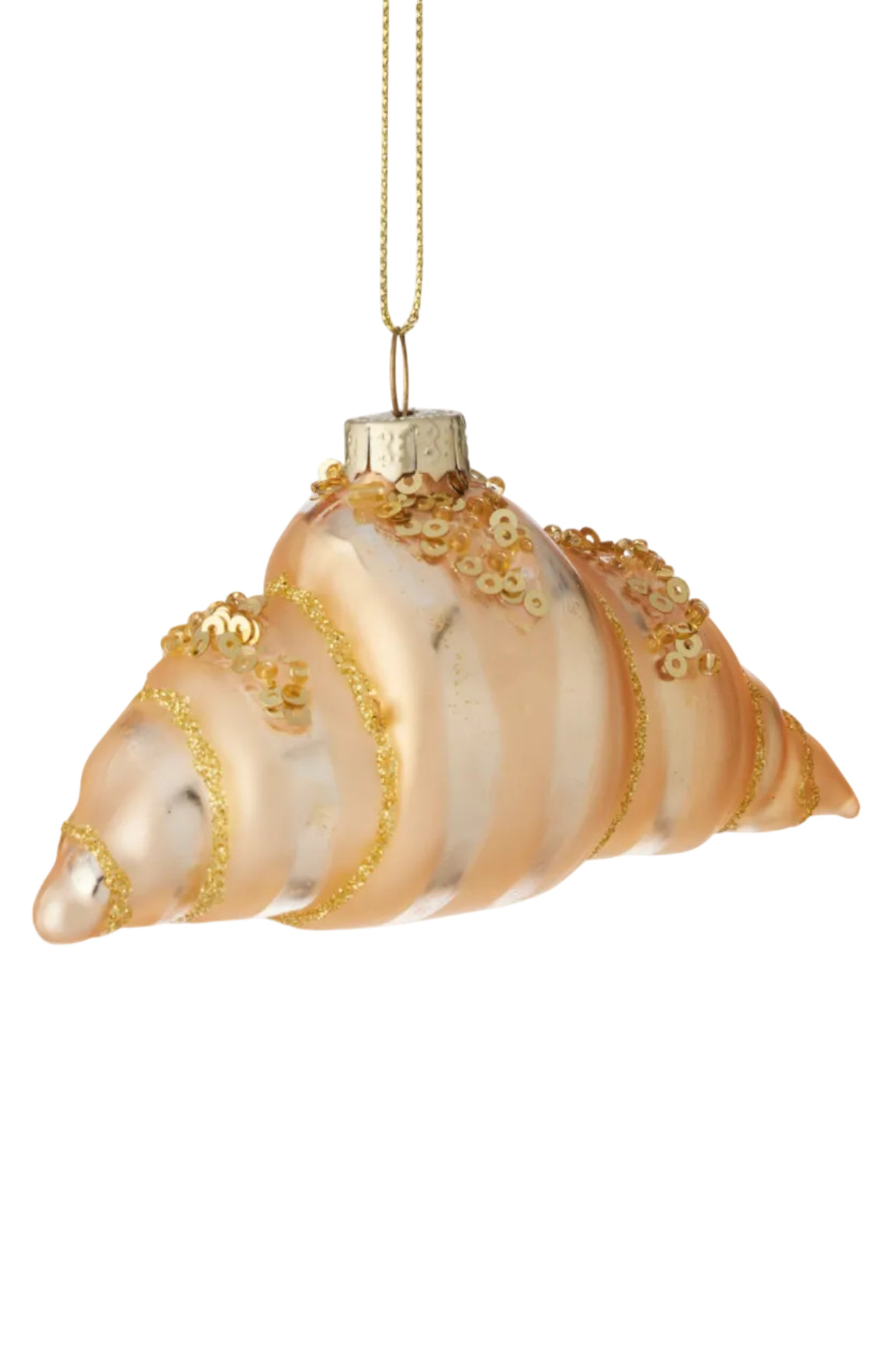 A seashell-shaped Christmas ornament in frosted peach glass with gold glitter stripes and small gold floral embellishments, hanging from a gold string against a white background.