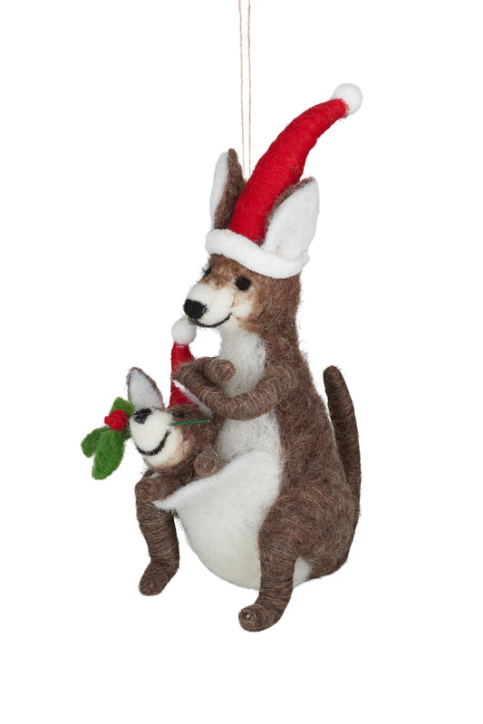 A felt wool kangaroo family Christmas ornament featuring a brown and white mother kangaroo wearing a red Santa hat and holding a small white baby kangaroo with a red Santa hat and green holly sprig, suspended by a string against a white background.