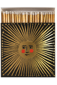 Matches with a decorative box featuring a sun and face design on a white background