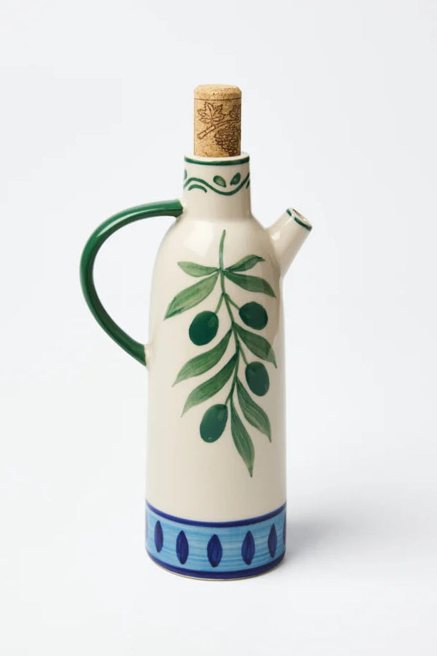 Ceramic olive oil bottle with green leaf design on a white background