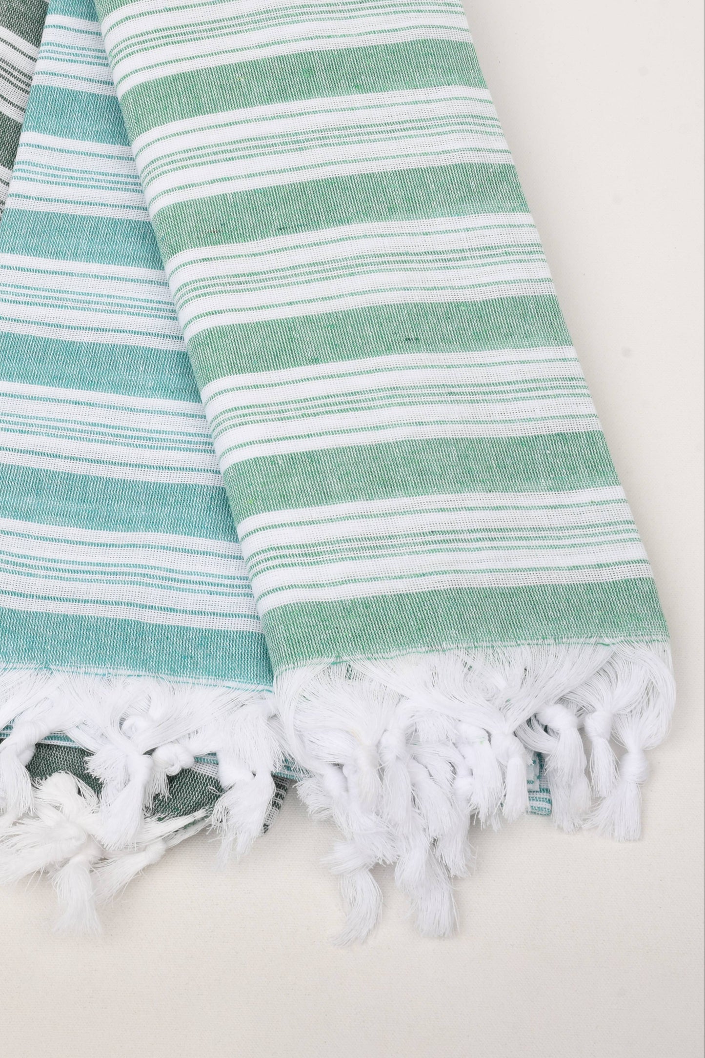 Three striped towels with fringes on a light background