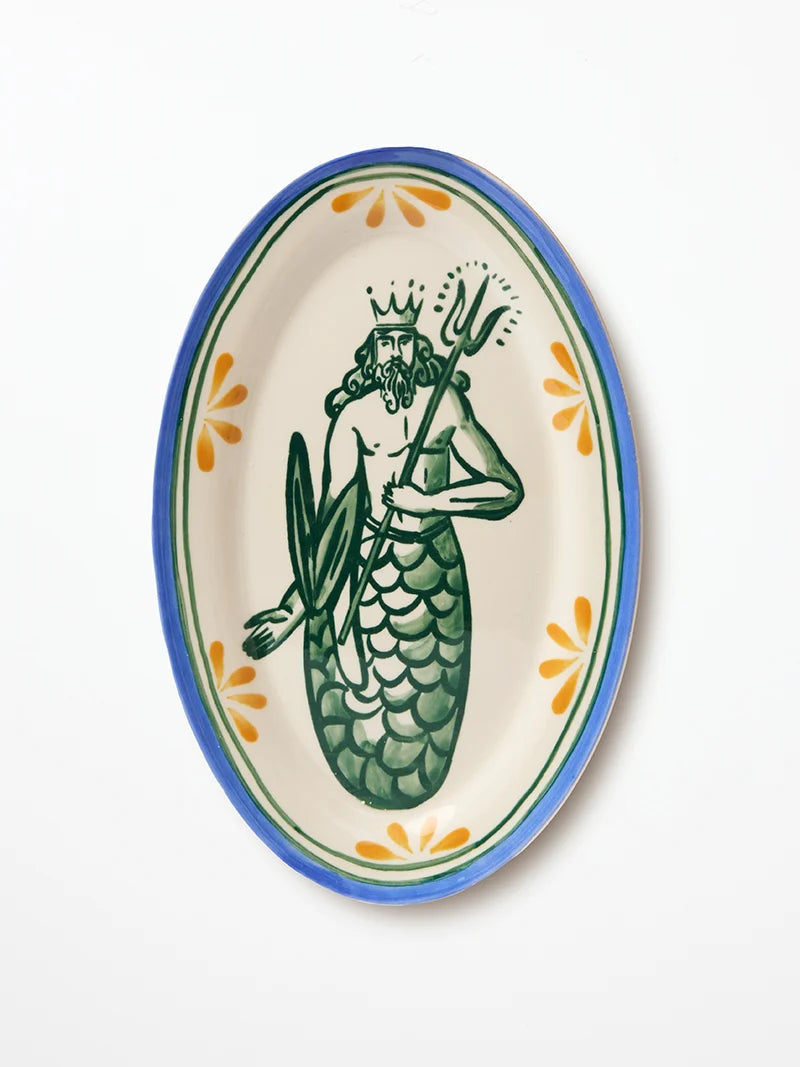 An oval ceramic serving platter featuring a hand-painted green illustration of Neptune holding a trident, with a blue and orange border on a white background.