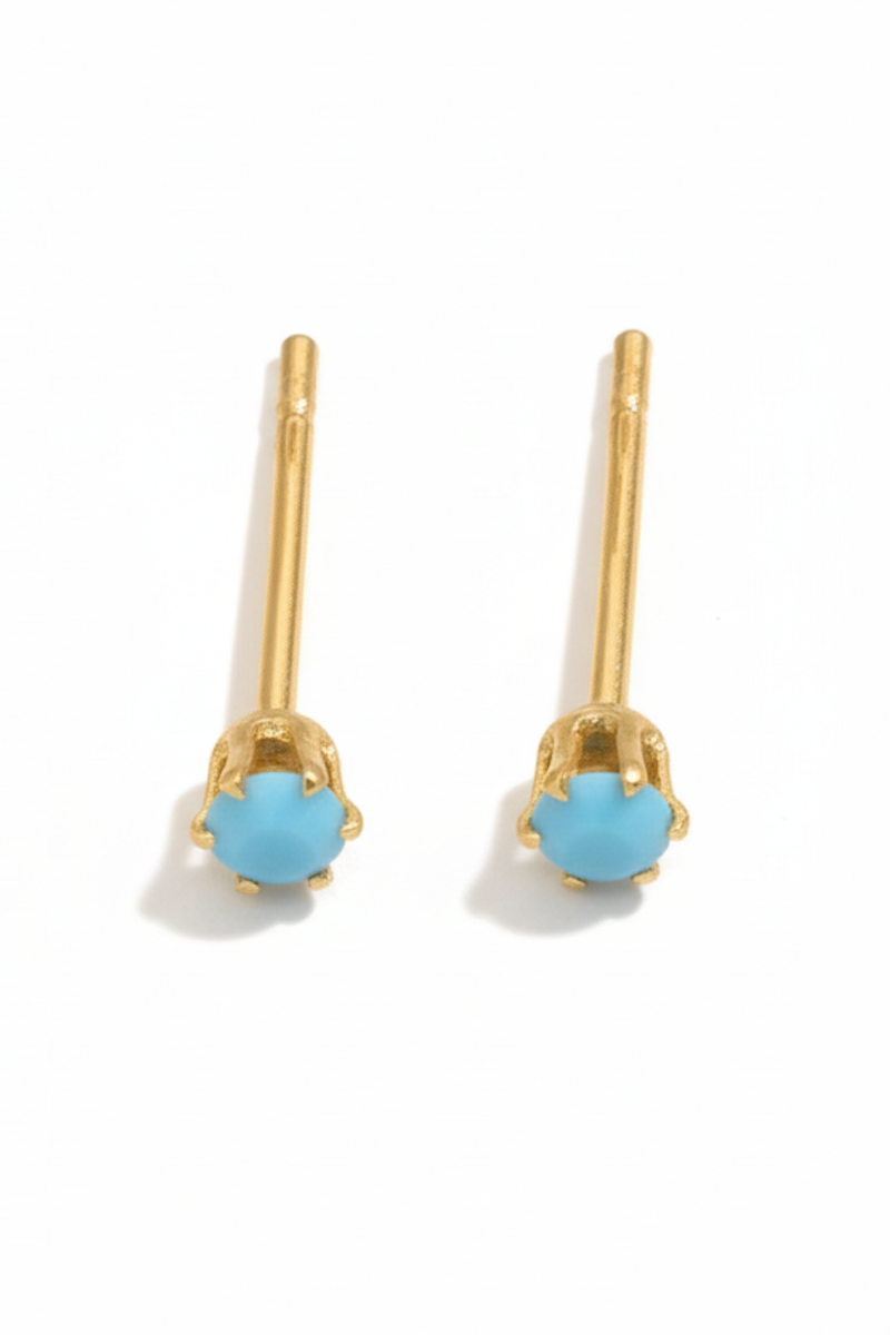 Pair of gold earrings with turquoise stones on a white background